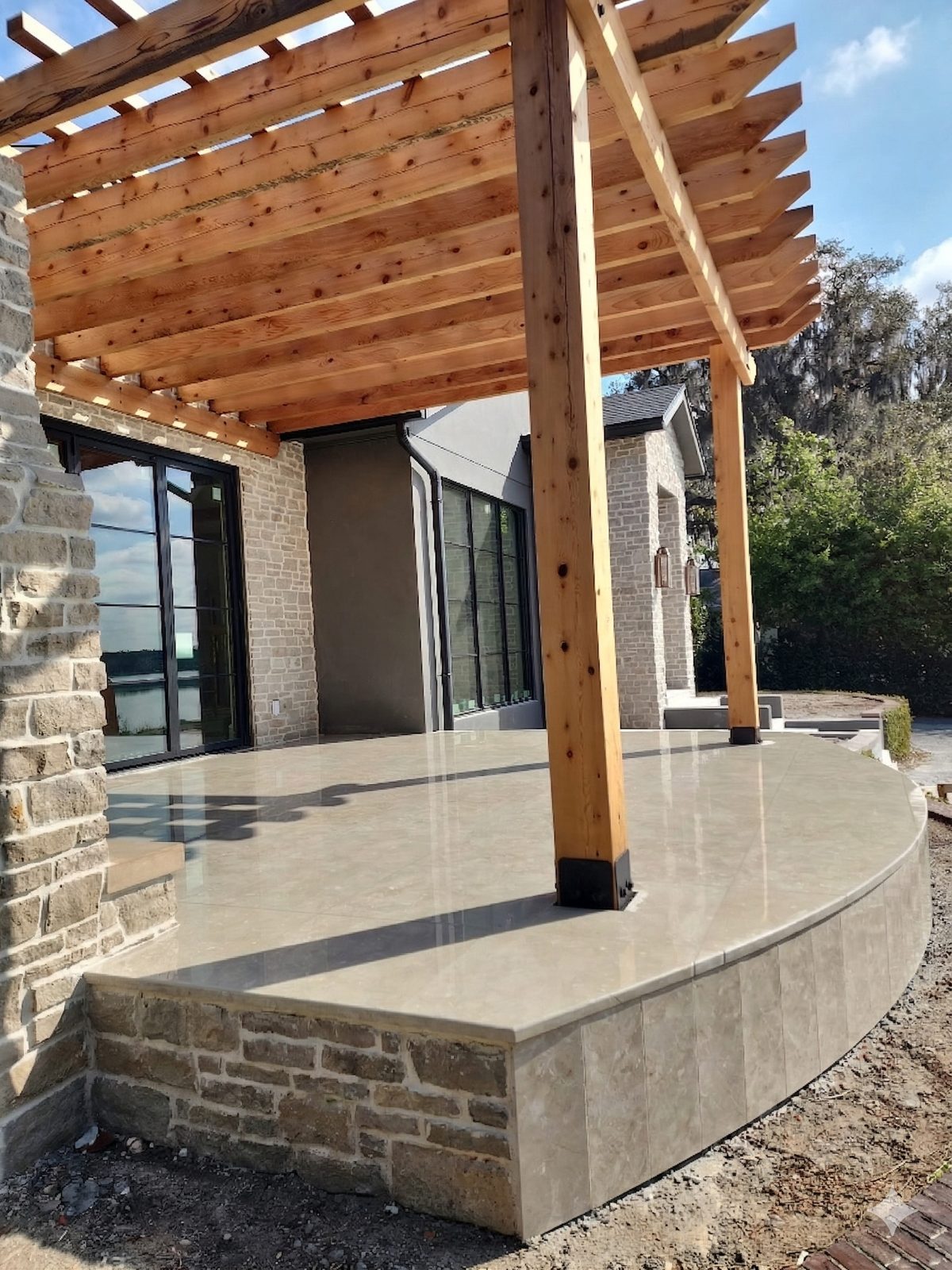 Travertine patio under a pergola by Lakewood Ranch Concrete in Lakewood Ranch, Manatee & Sarasota